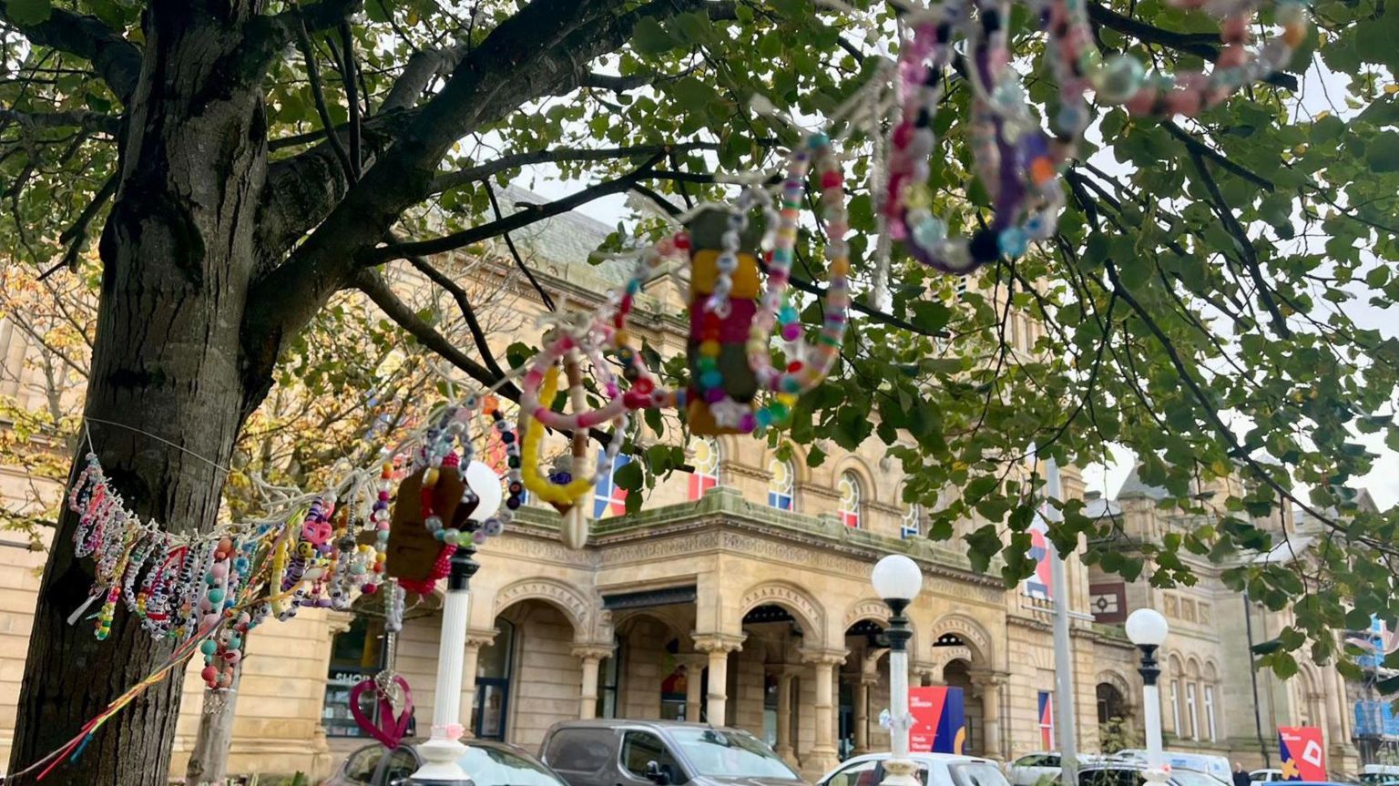 Garlands made from friendship bracelets hanging in trees in the town