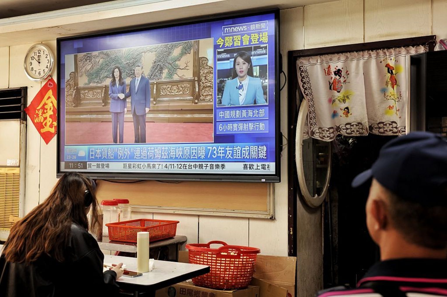 电视画面显示台湾在野党国民党主席郑丽文于 2026 年 4 月 10 日在北京与中国国家主席习近平会面的场景，拍摄地点是台北一家餐厅。