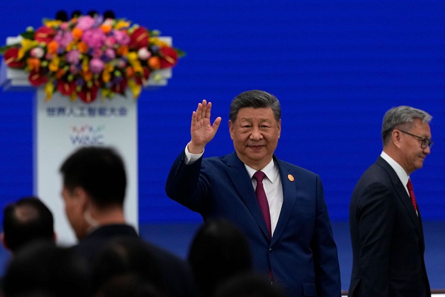 习近平举手找招呼，背景是蓝色底