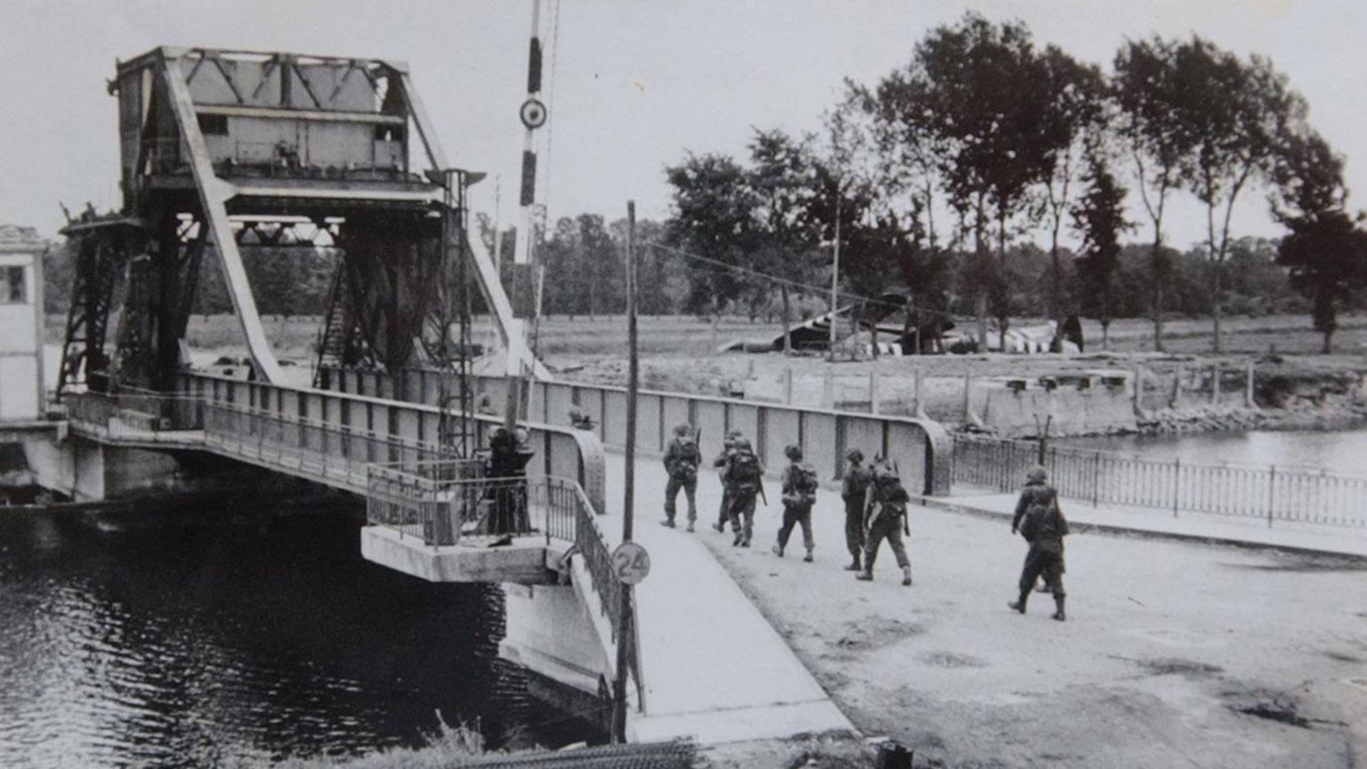 Troops crossing Pegasus Bridge - a black and white photo from 1944