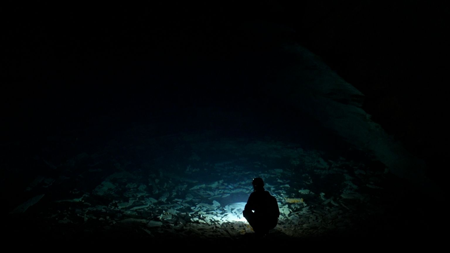 Flooded part of the mine - with member of staff silhouetted against the water in a chamber