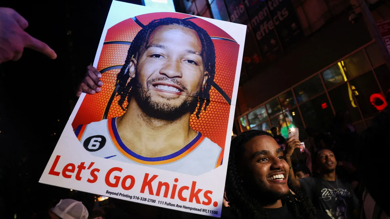 REUTERS/Shannon Stapleton A man holds a poster of New York Knicks point guard Jalen Brunson, as fans gather in Times Square.