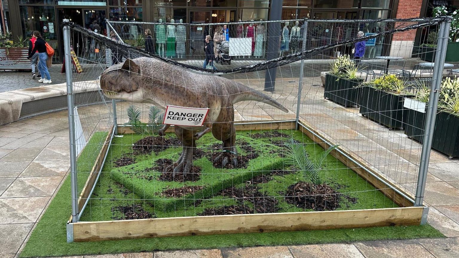 A model T-rex in a cage in Lincoln city centre
