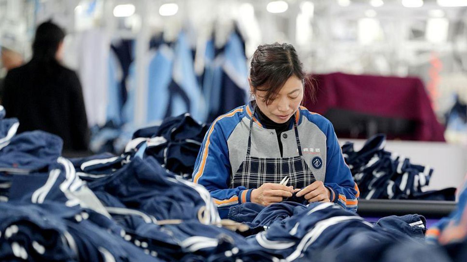 女工在流水线上裁剪服装