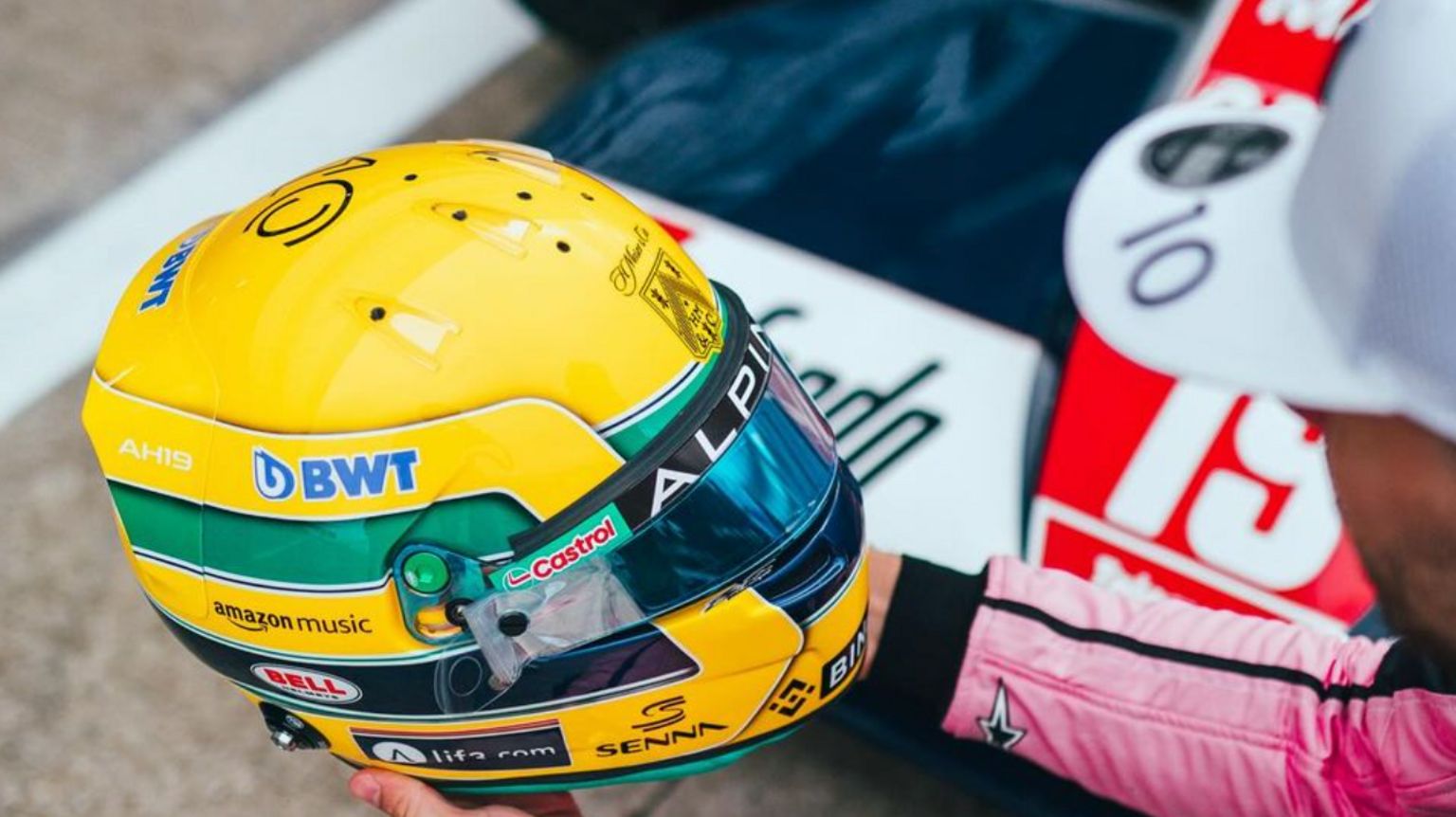 Pierre Gasly holds his Senna-inspired tribute helmet 
