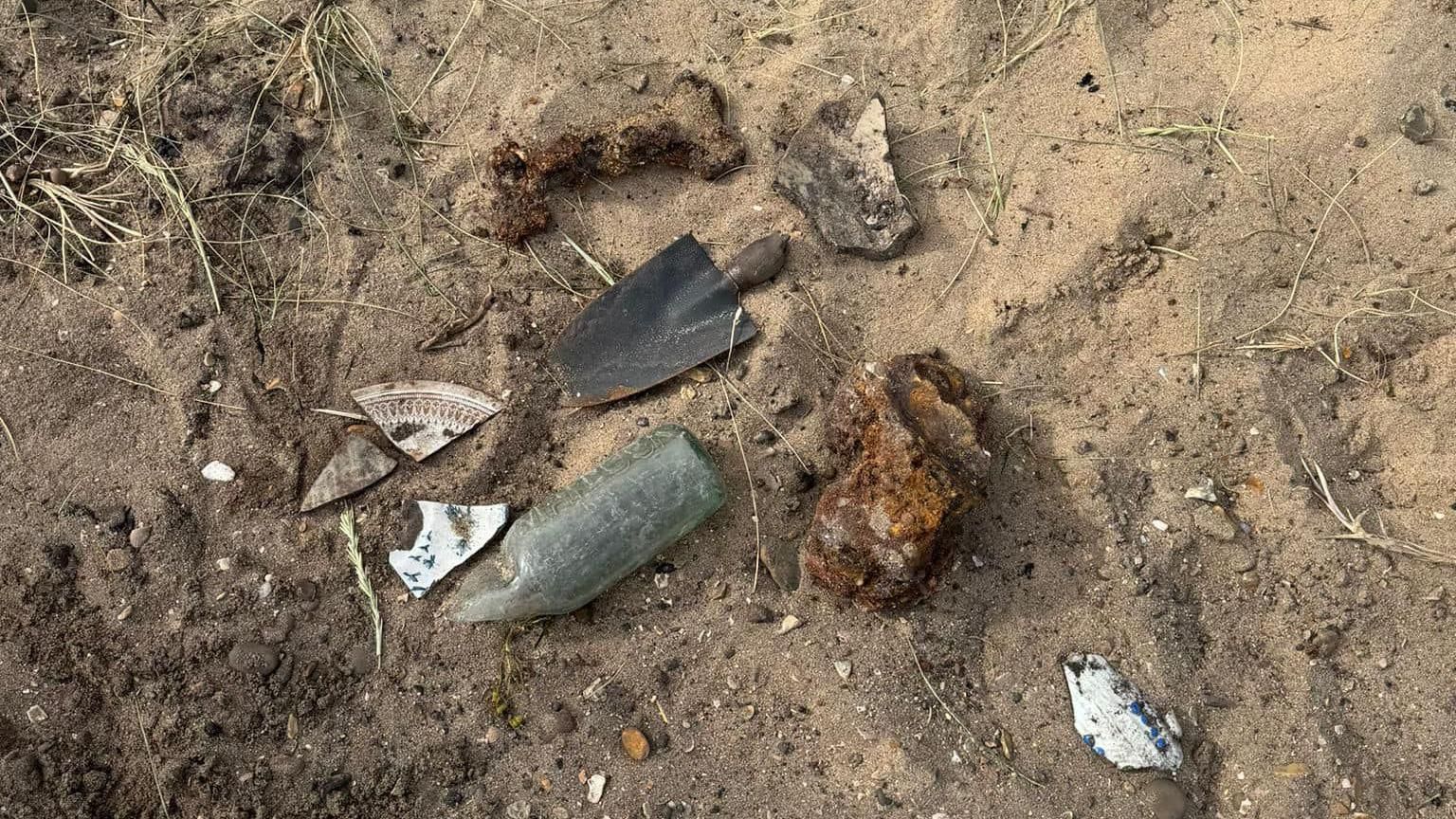 A small spade and shells found on on the beach