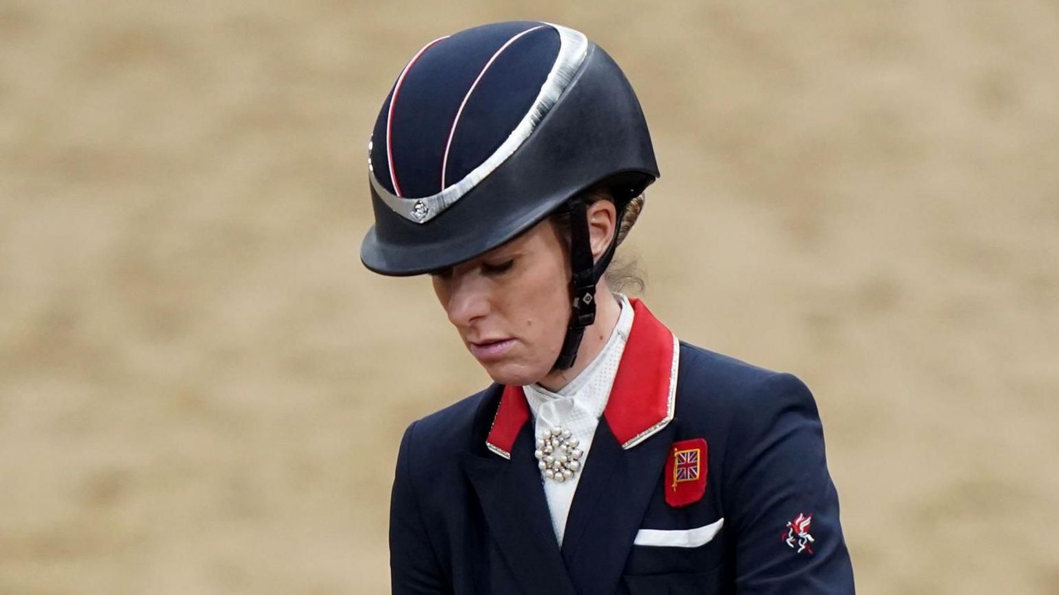 Charlotte Dujardin wearing in her dressage uniform looking down