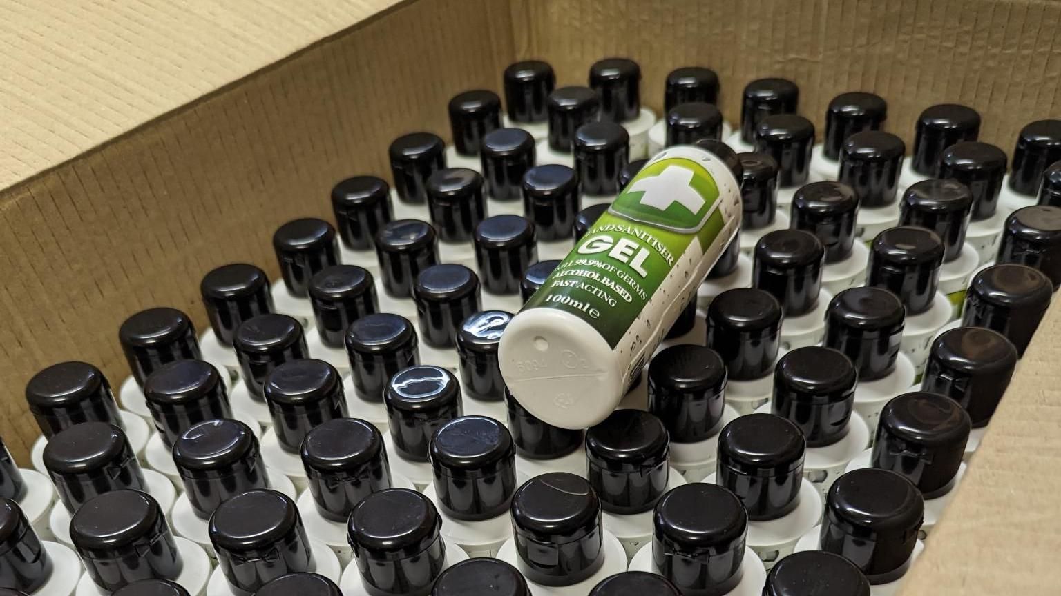 A picture shows a cardboard box containing plastic bottles of the seized counterfeit hand sanitiser.