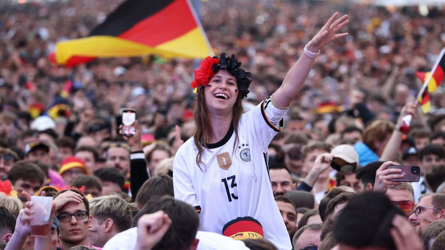 A huge crowd of Germany fans dressed in football kit celebrate as the team play in Euro 2024