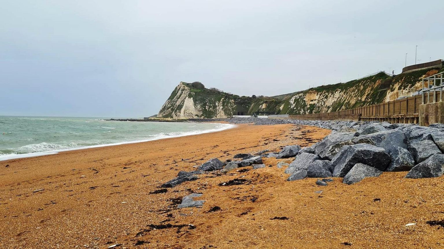 Shakespeare Beach, which has sand in the foreground and a headland in the background.