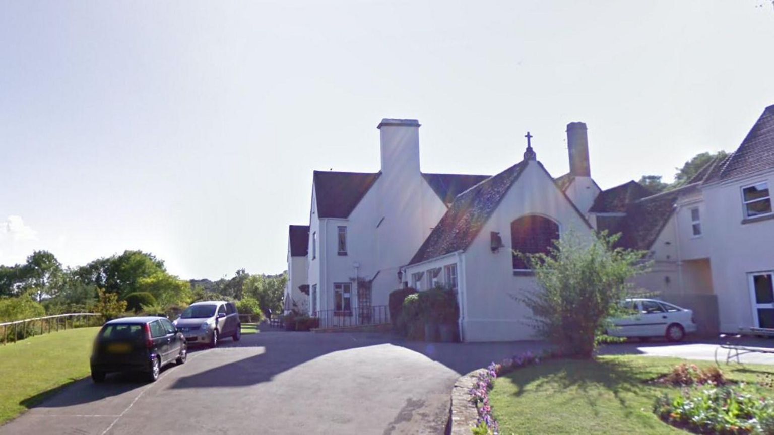 Resthaven Nursing Home. It is a white building with a dark roof. Plants and cars can be seen near the building.  