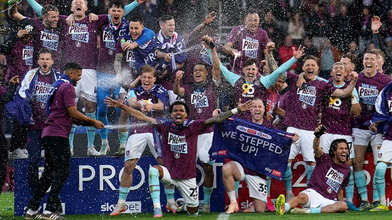 PA Media Burnley's players celebrate promotion to the Premier League on the pitch