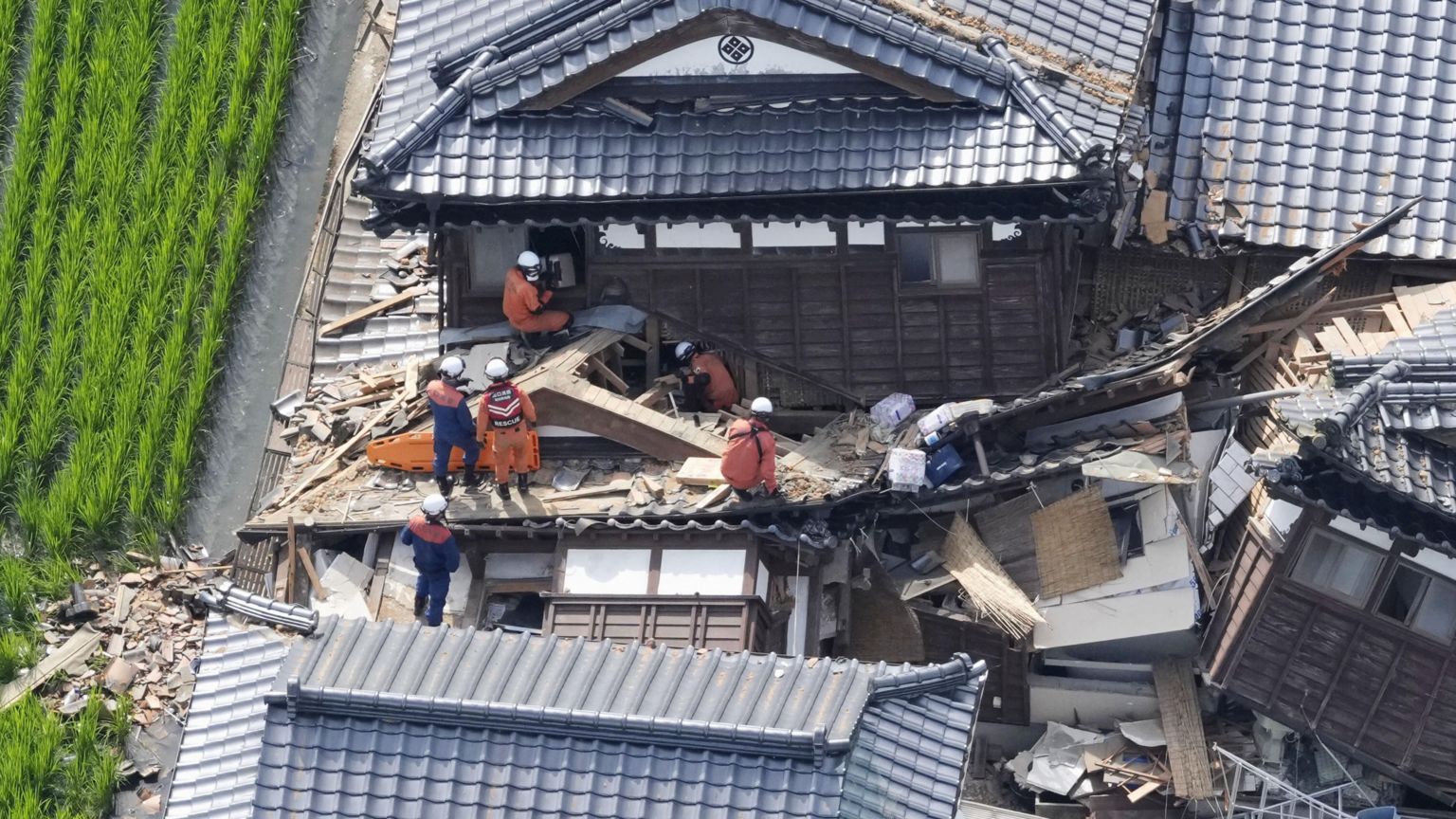 2026年7月29日，日本熊本县冰川町，救援人员在一栋地震中倒塌房屋搜救