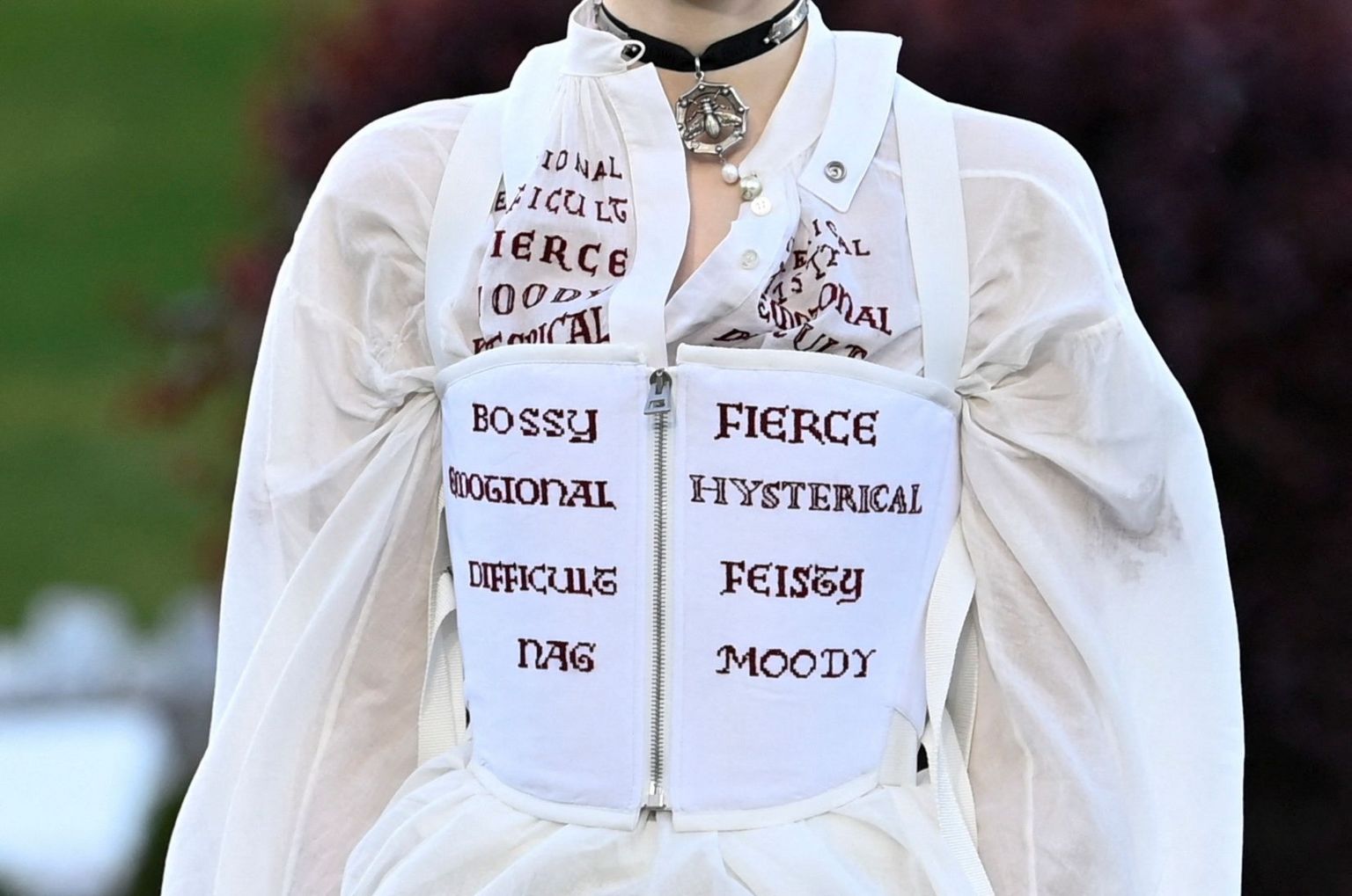 A model presents an outfit featuring embroidered insults used for woman