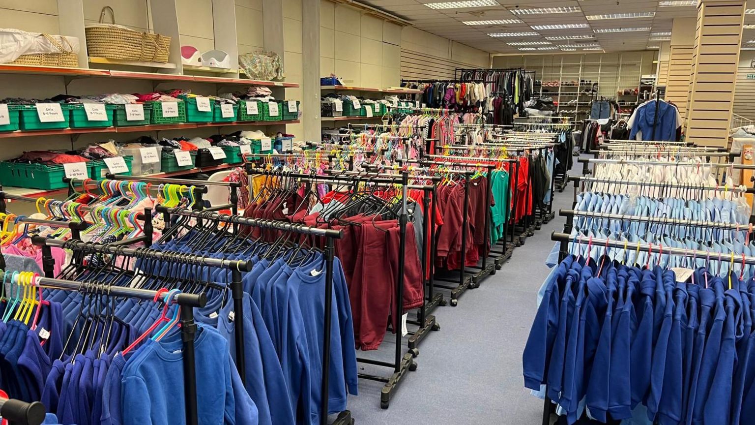Old shop floor filled with uniforms on rails