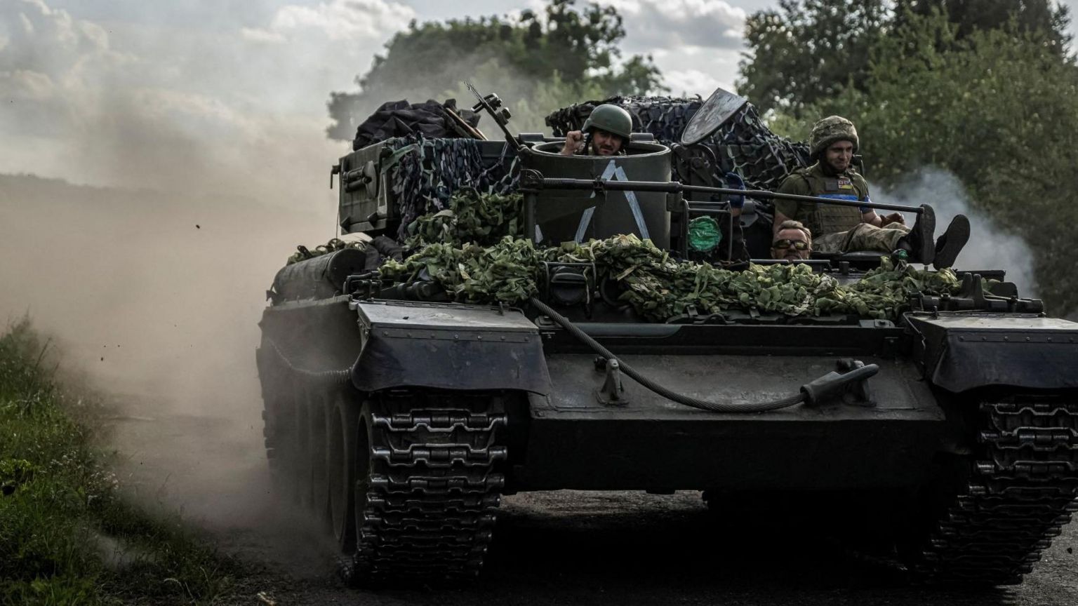 Ukrainian servicemen ride a military vehicle, amid Russia's attack on Ukraine, near the Russian border in Ukraine's Sumy region