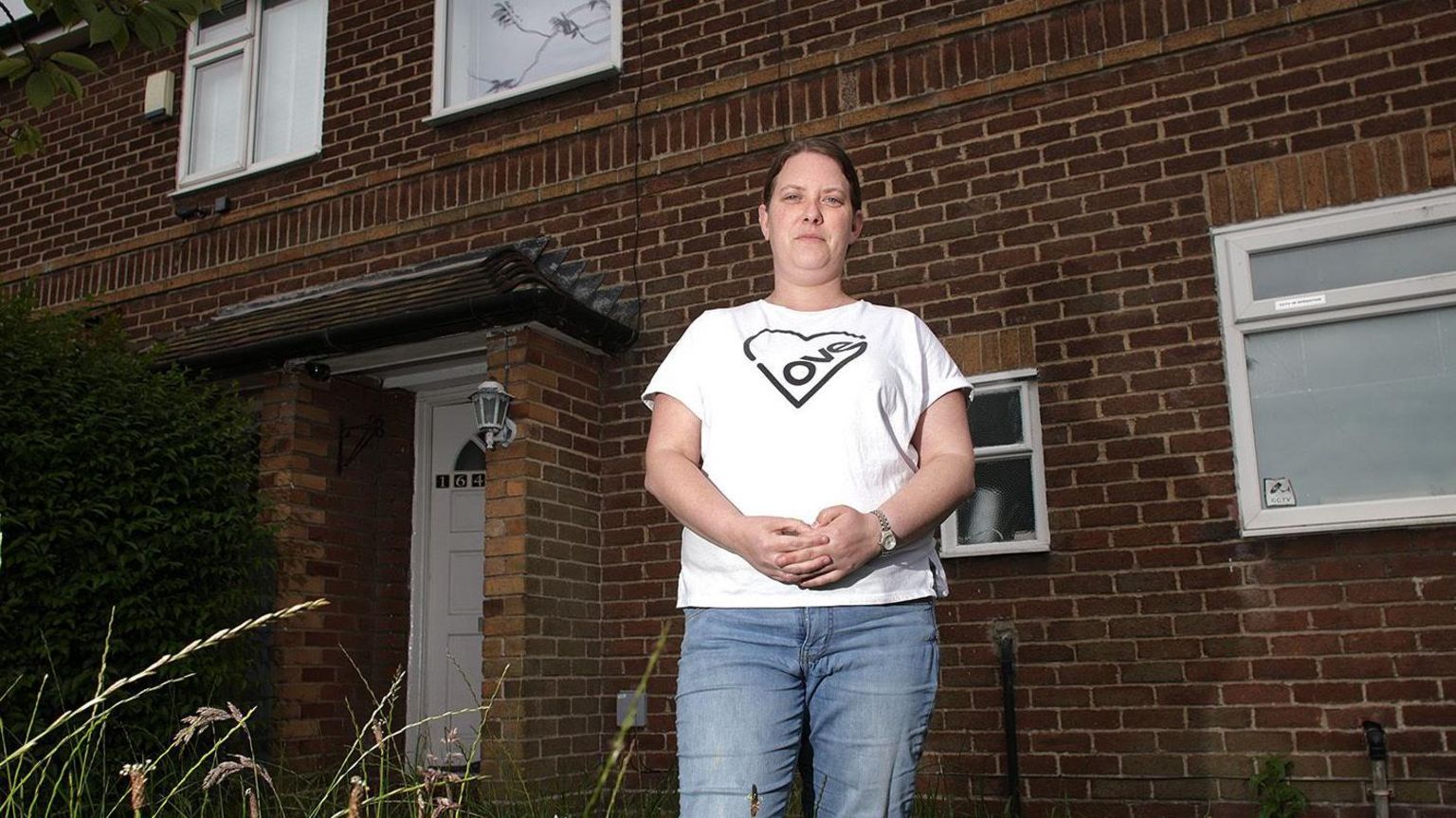 Katie Collins stands outside her temporary housing in Swinton 