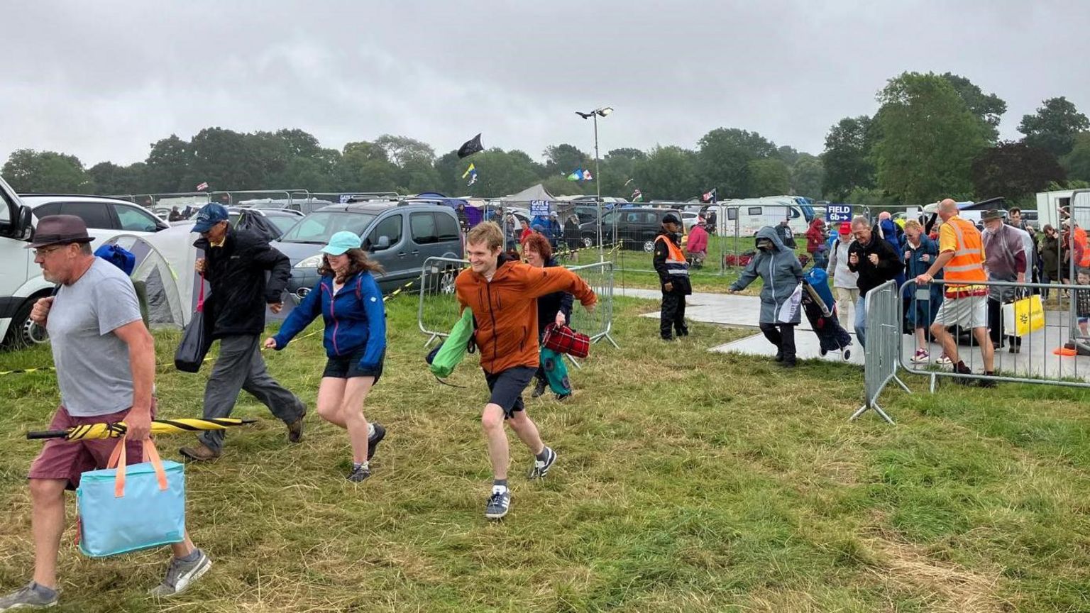 A group of people in coats running across grass.