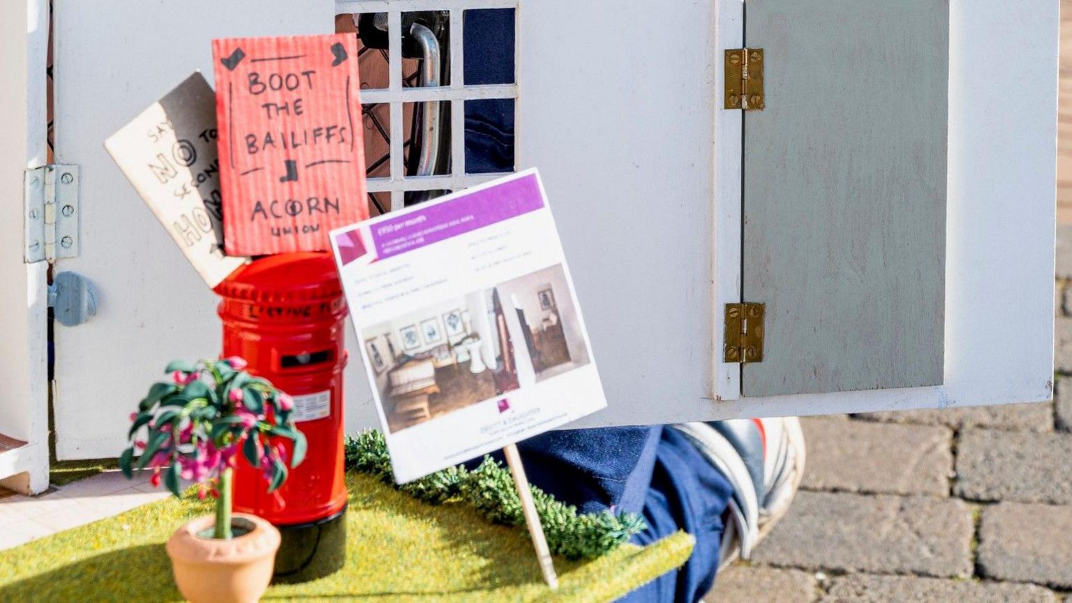 A close up of Bryony Devitt's doll's house with protest signs