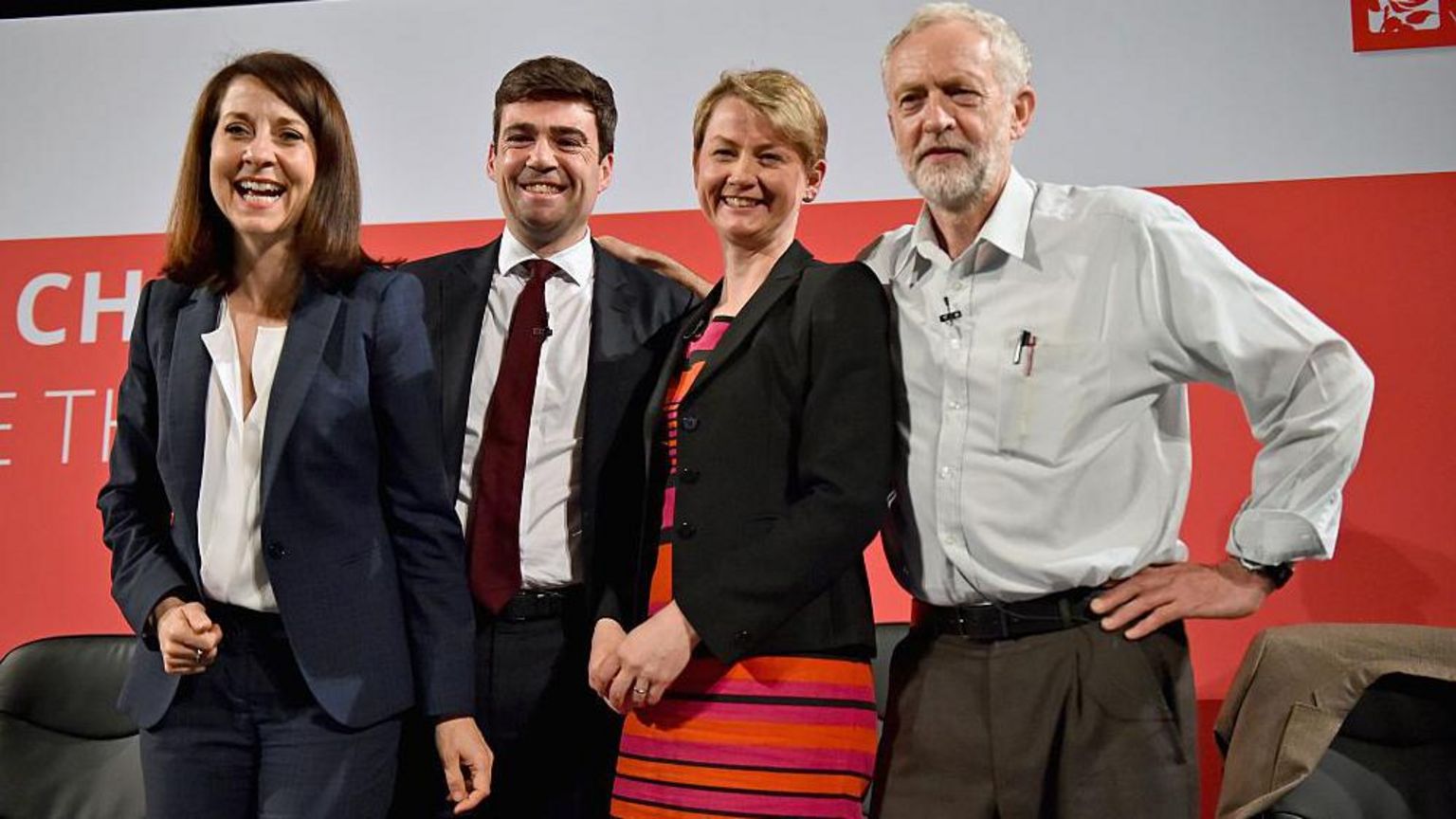 利兹·肯德尔（Liz Kendall）、安迪·伯纳姆、伊薇特·库珀（Yvette Cooper）和郝尔彬。安迪·伯纳姆身穿深色西装、白色衬衫和深红色领带。郝尔彬穿着浅灰色衬衫，最上方钮扣松开，没有打领带。他的上衣口袋里插着几支笔。