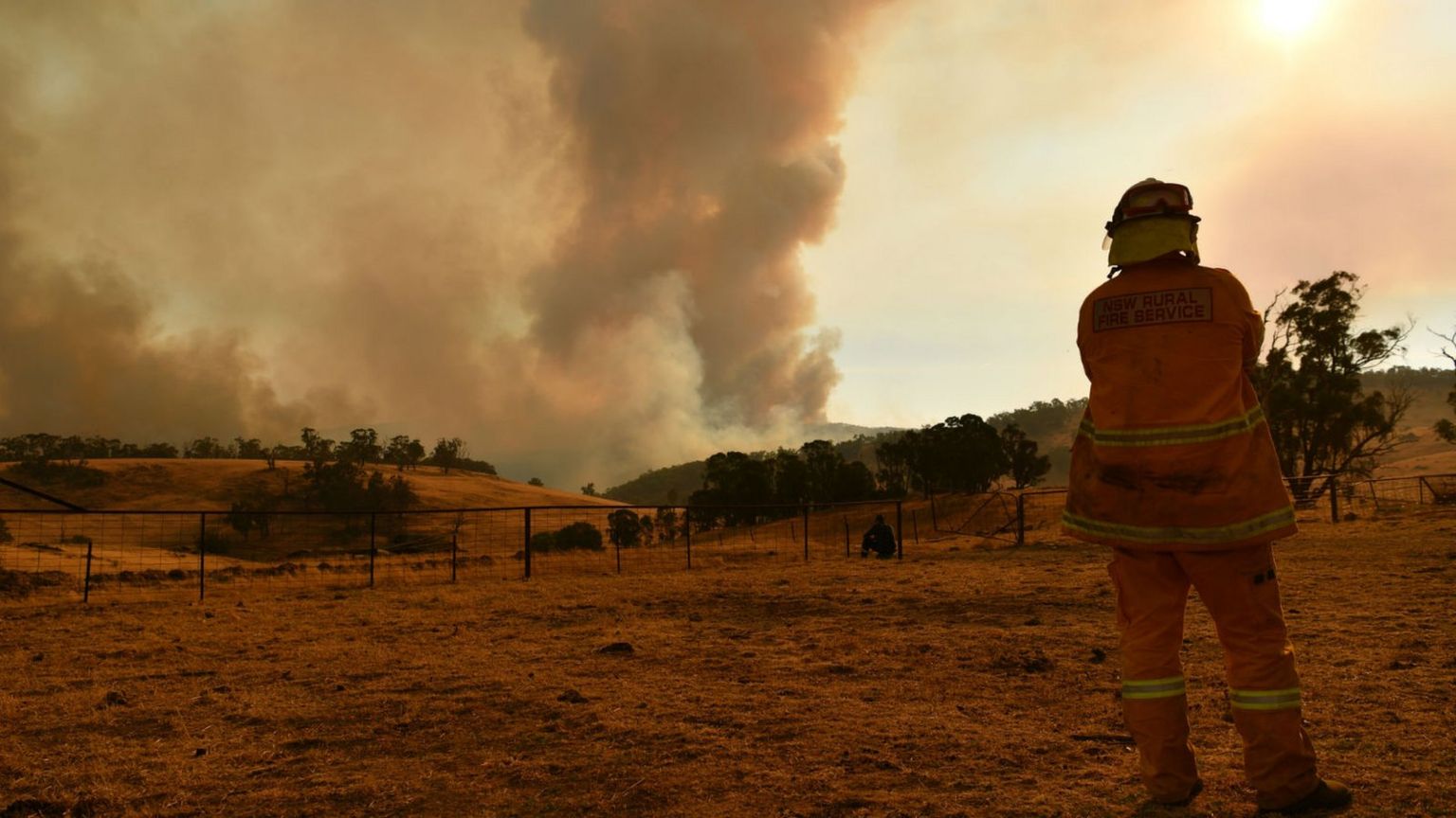 A Rural Fire Service firefighter looks at smoke in Tumburumba on 11 January 2020.