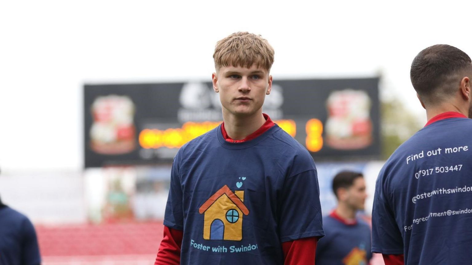 Swindon Town Defender Harley Hunt wears a t-short to promote foster caring at the County Ground