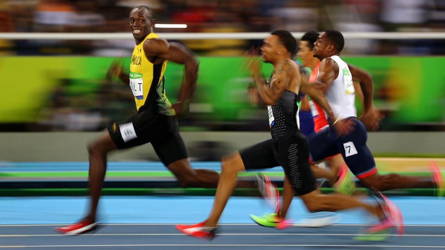 Usain Bolt running in a race with three athletes behind him