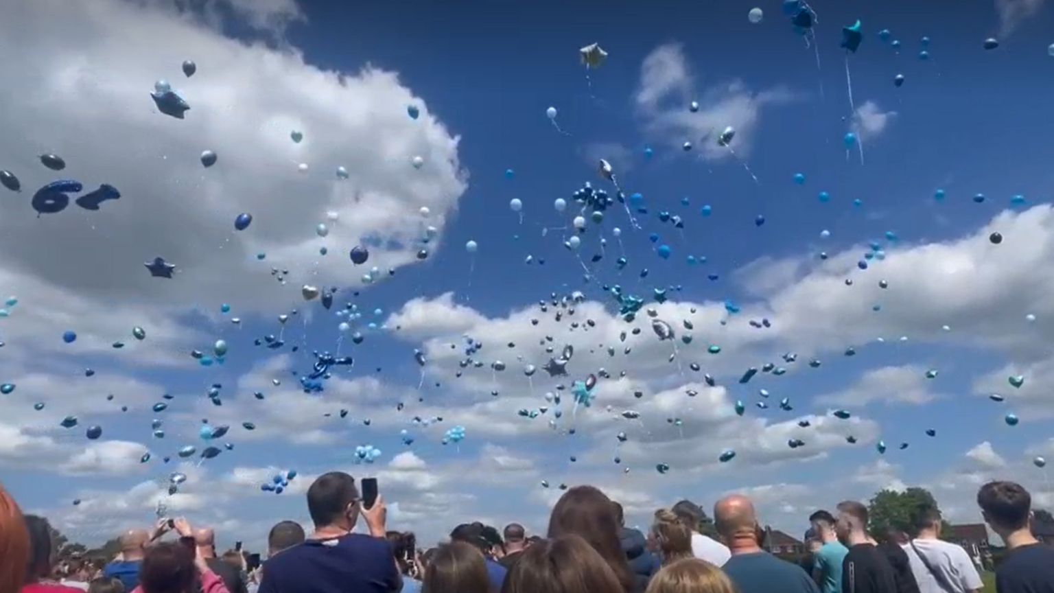 Hundreds of balloons in different shades of blue being released into the air in Carlon-in-Lindrick, Nottinghamshire