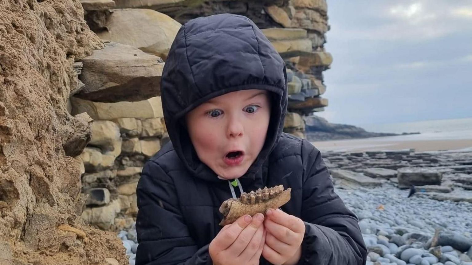 Dylan Rees holding a fossil 