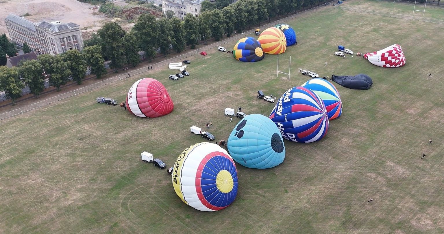 Aerial shot of balloons on the ground. Most are inflated.