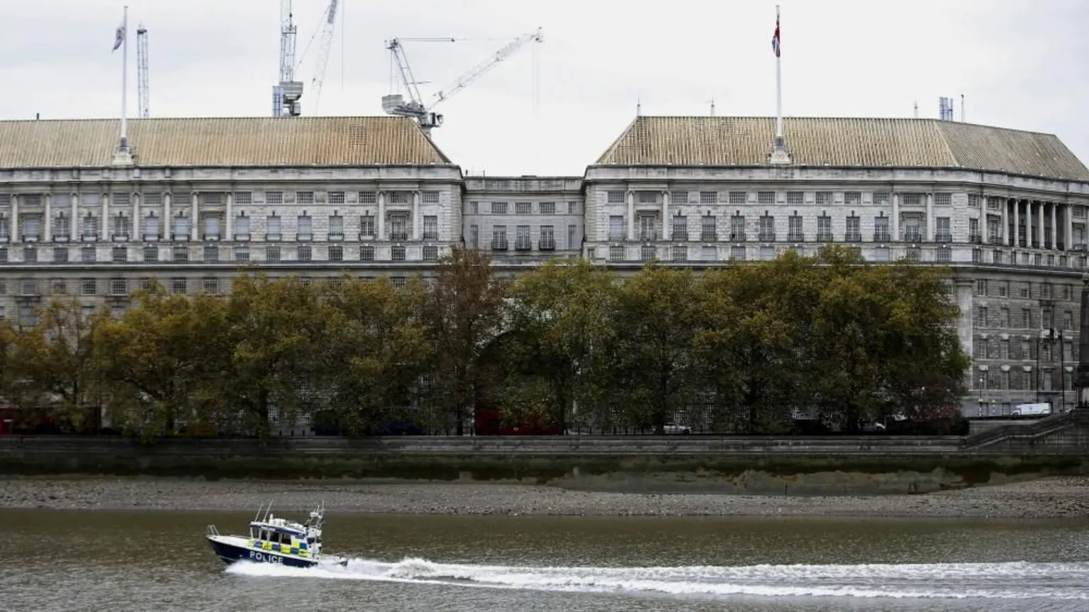 Reuters The image shows a huge grey office block shown on the banks of the River Thames, with a police boat in the foreground in the water