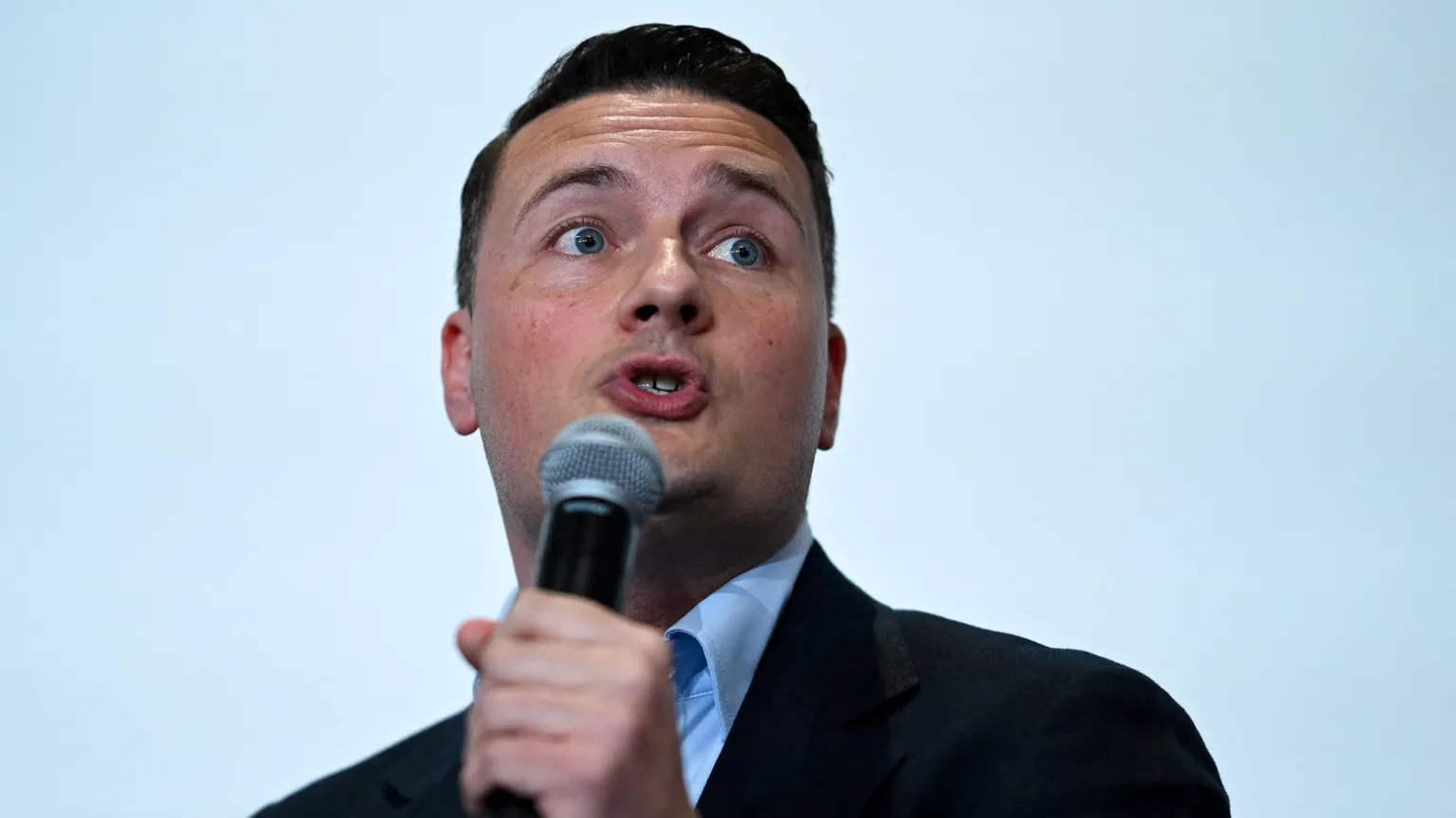 Reuters Britain’s former Health Secretary Wes Streeting delivers a keynote address on 16 May, with a microphone held in his hand.