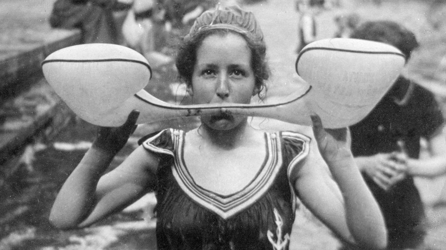 A black and white photo of a student in river with a floating aid in front of her face. 