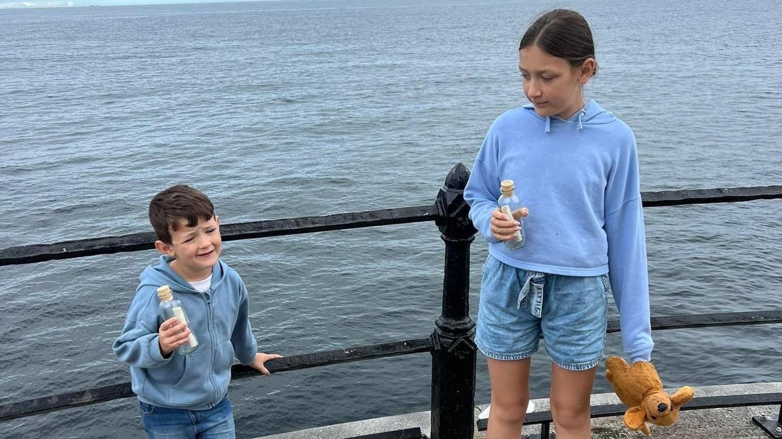 Harry Liddle, left, and his sister Grace getting ready to throw their bottles off Roker Pier