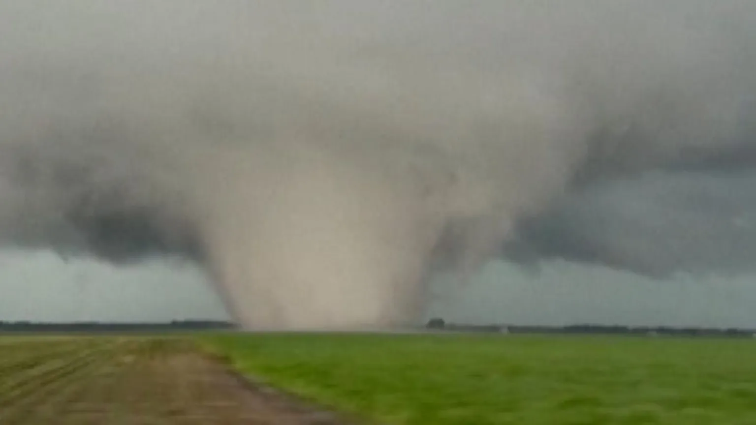 A large, wide tornado in a field