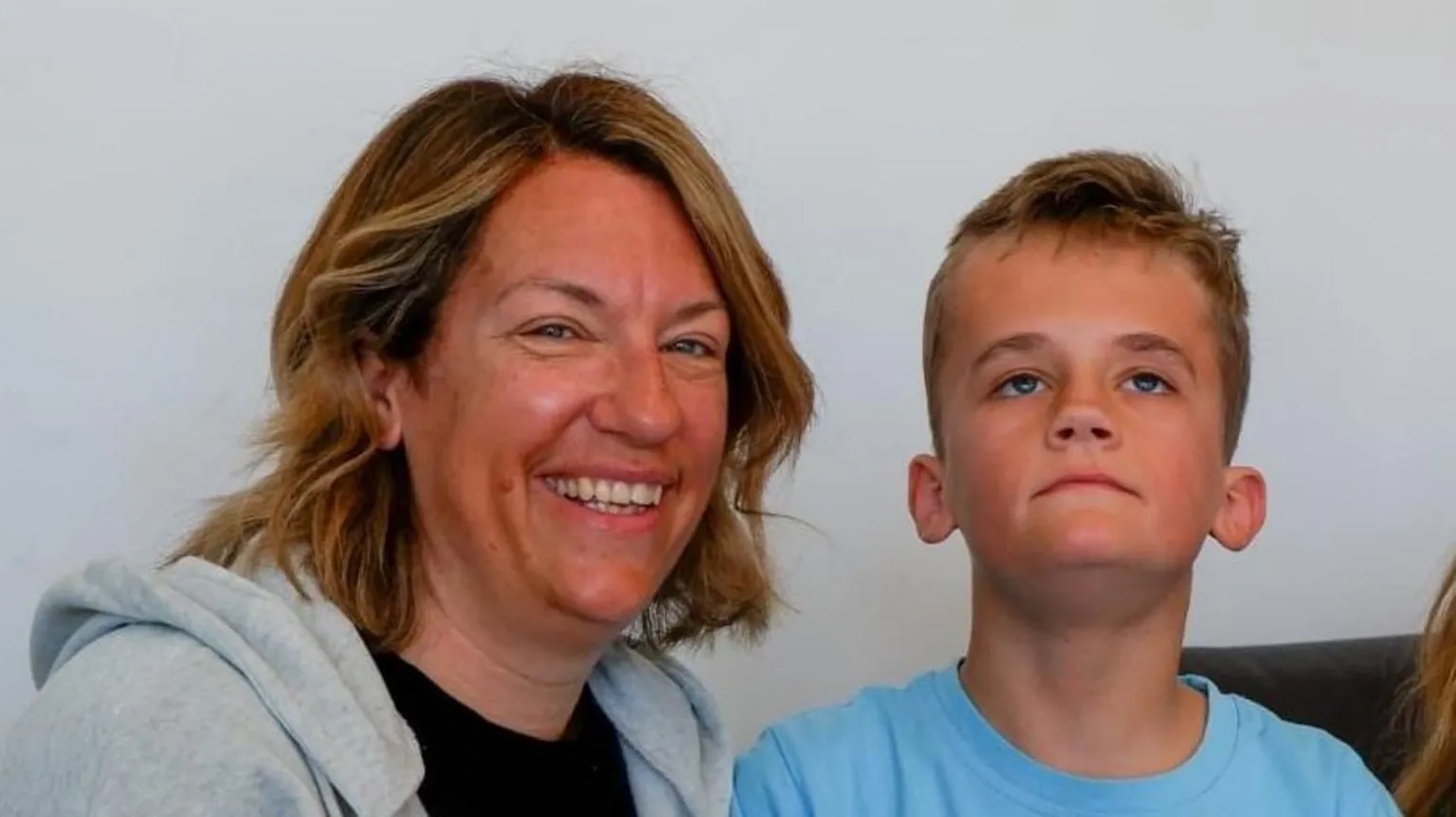 Supplied A woman wearing a grey hooded top over a black T-shirt. Next to her is a young boy wearing a blue T-shirt. He is looking upwards while the woman is smiling and looking into the camera.