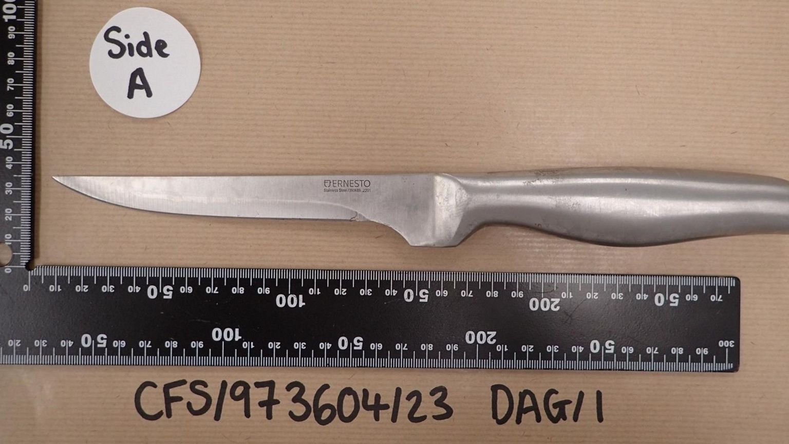 The knife alongside measurement rulers