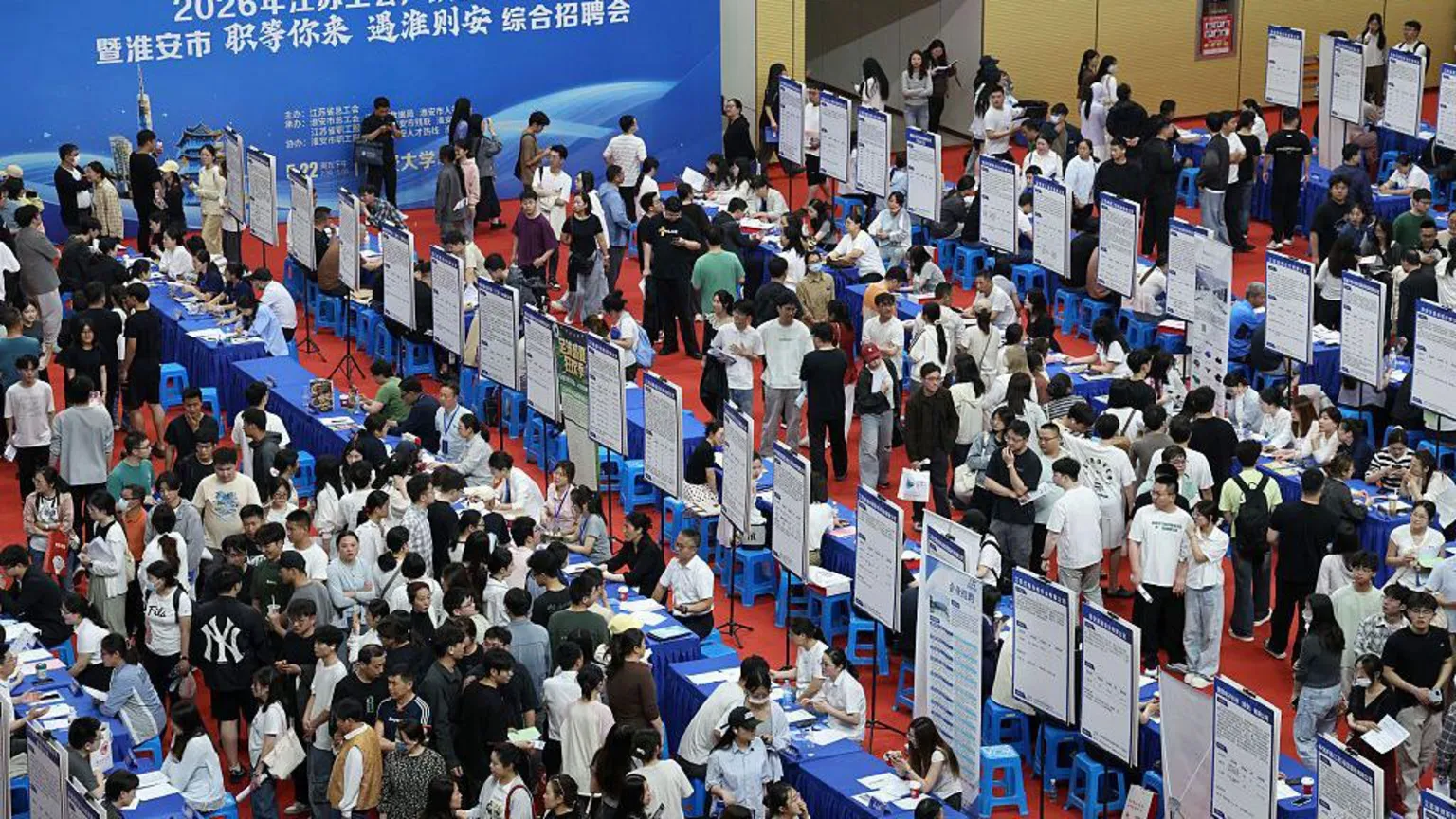 Getty Images Job seekers look at recruitment notices at a job fair targeting college graduates and other job seekers held in the Huai'an University Gymnasium in Huai'an, in China's eastern Jiangsu pro