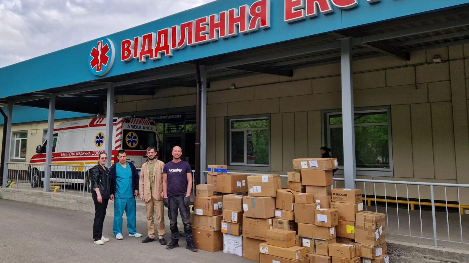 Brian and Helen Hammond in Ukraine, next to boxes of donated aid items