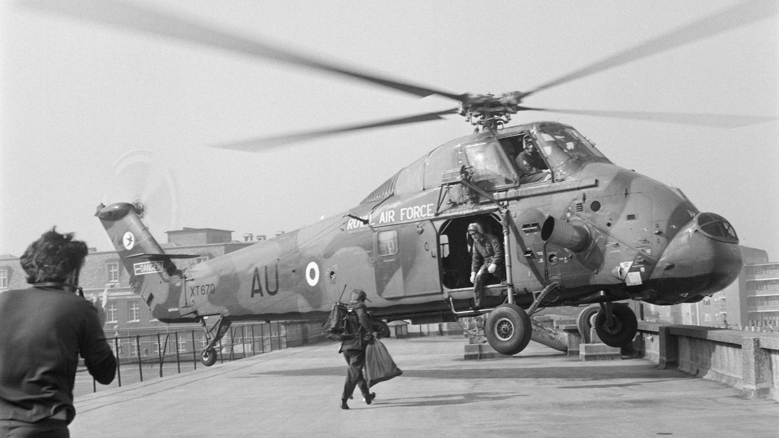 A Wessex Helicopter preparing to land on a roof top in London in a black and white photograph