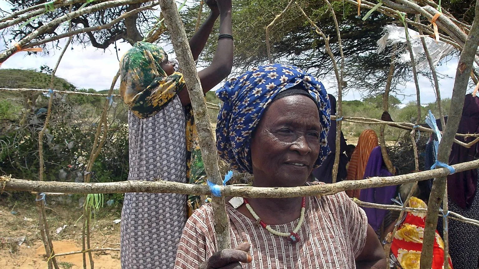 AFP via Getty Images Two women constructing a makeshift shelter at a camp in Elasha Biyaha in September 2007