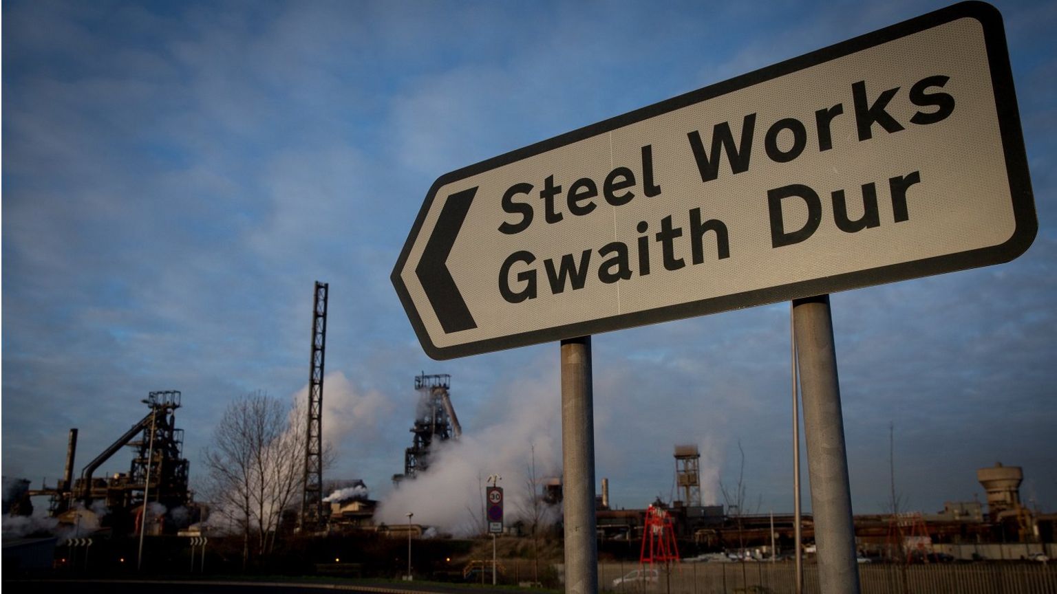 A street road sign shows the way to Tata steelworks in Port Talbot, Wales.