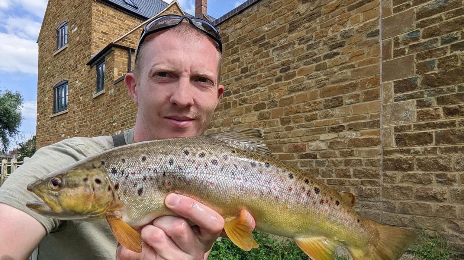 Liam McCarlie holding a fish he has caught.