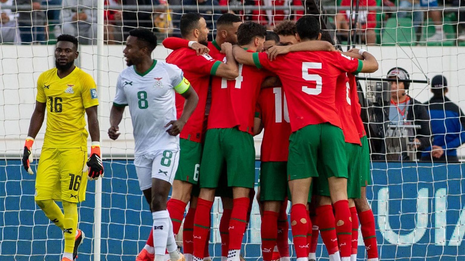 Moroccan players form a huddle as they celebrate a goal against Zambia