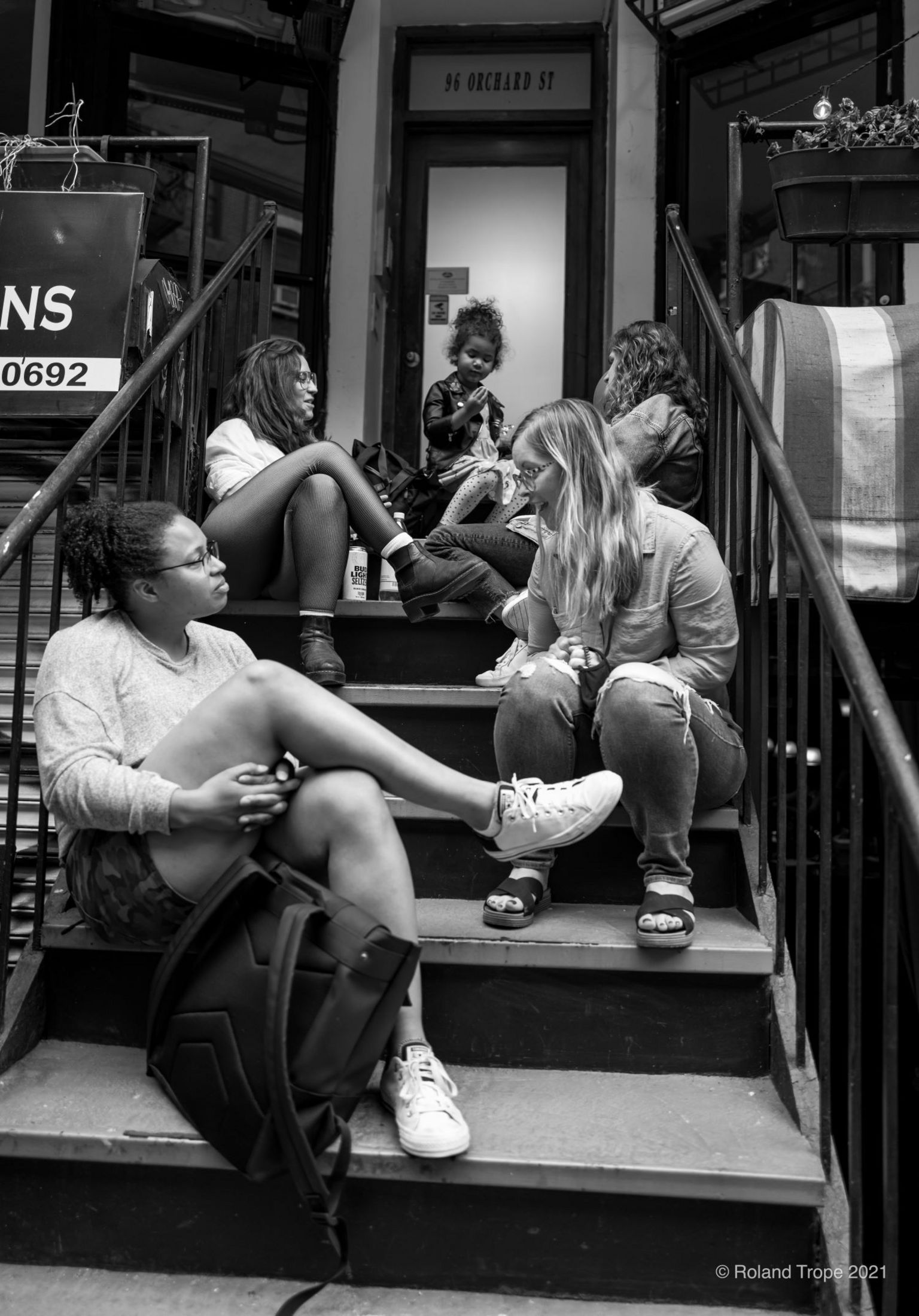 People talking to each other while sitting on steps in front of a house