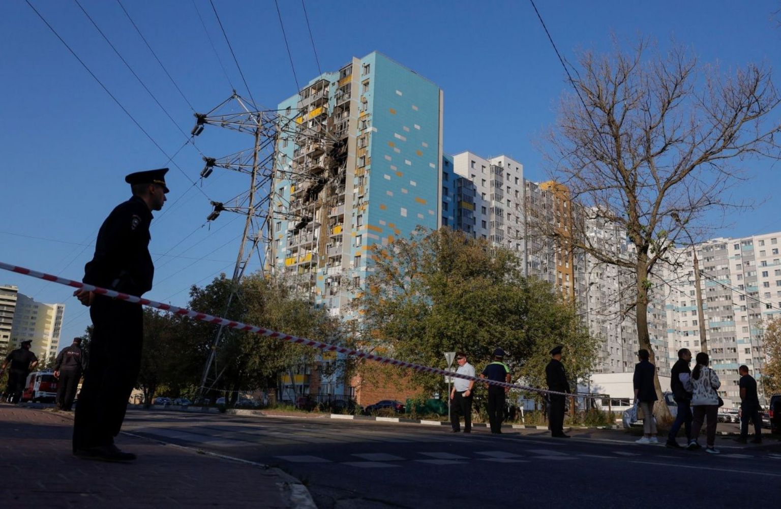 Guard standing outside an apartment block that was hit by Ukrainian drones