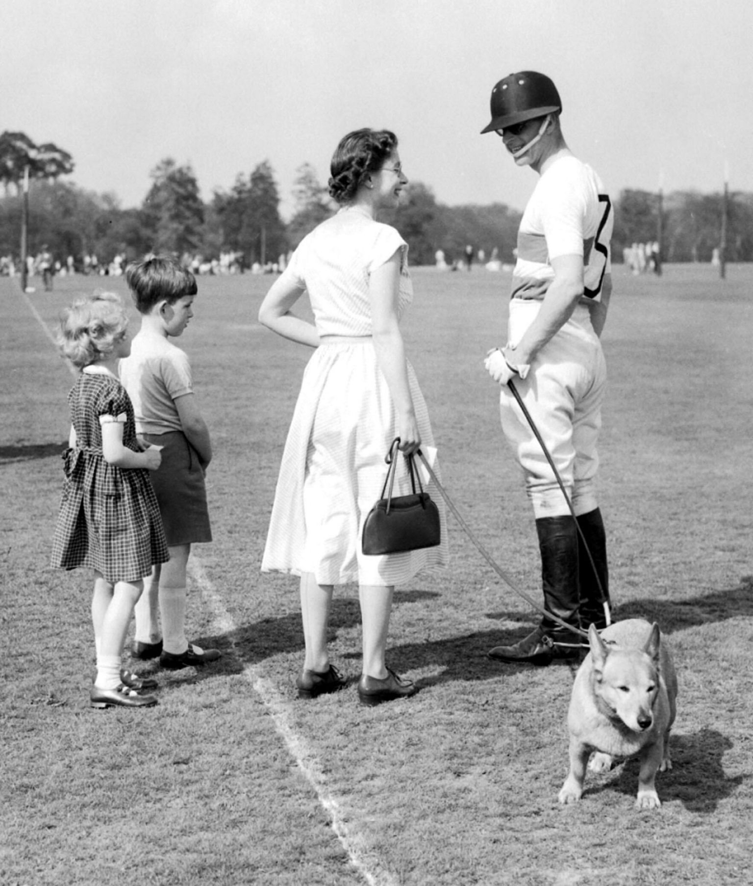 The Queen, with one of the Royal corgis, chats with polo-playing Prince Philip at Windsor Great Park