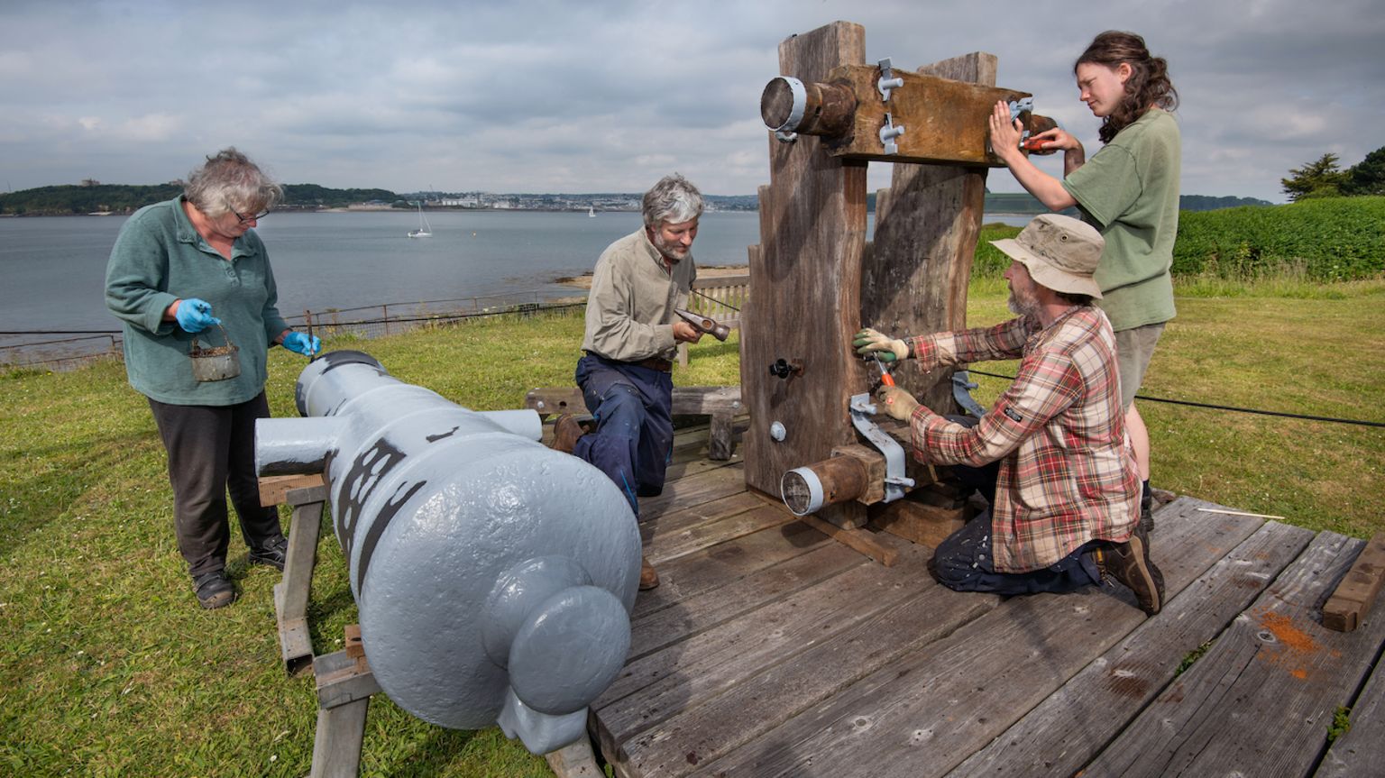 Conservators working on a cannon