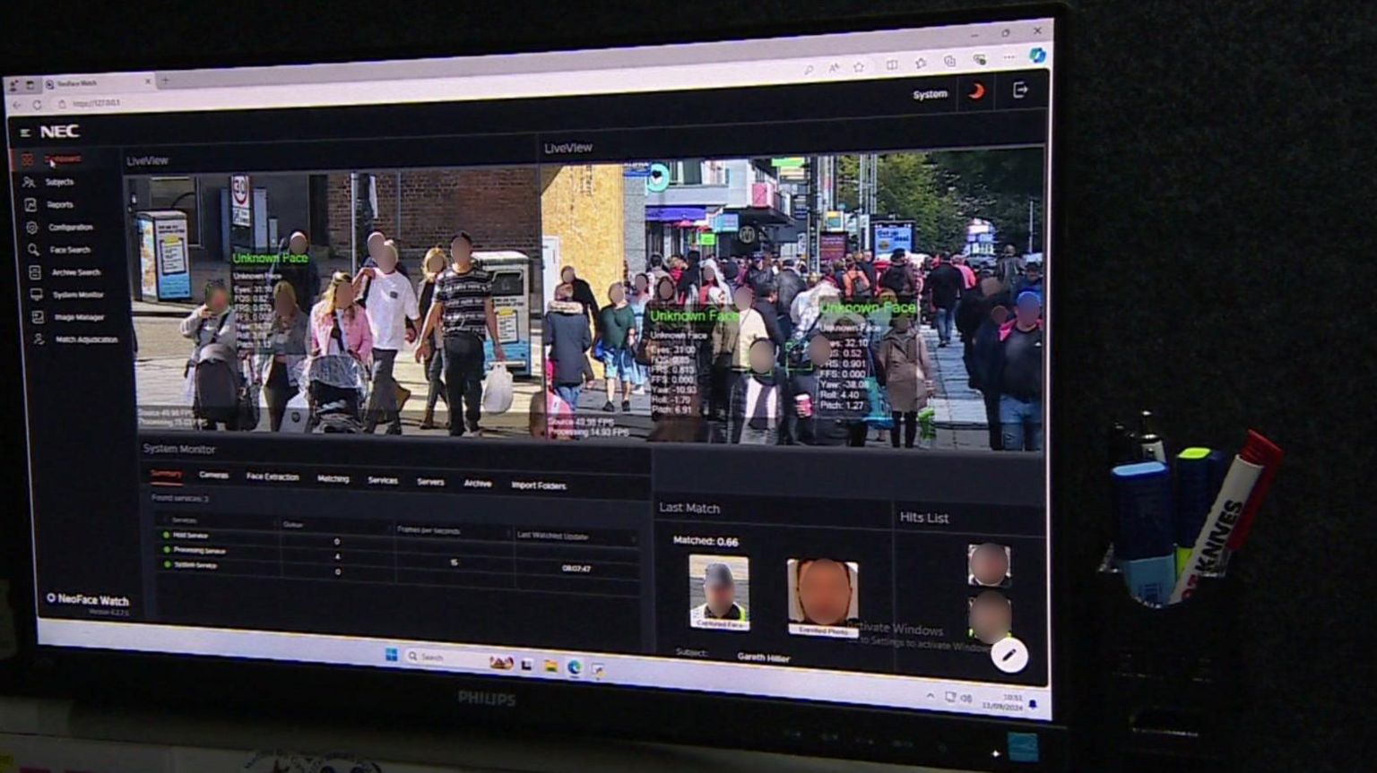 View of computer screen showing software running with live images of people walking in a screen while their faces are scanned and text appears on screen alongside them