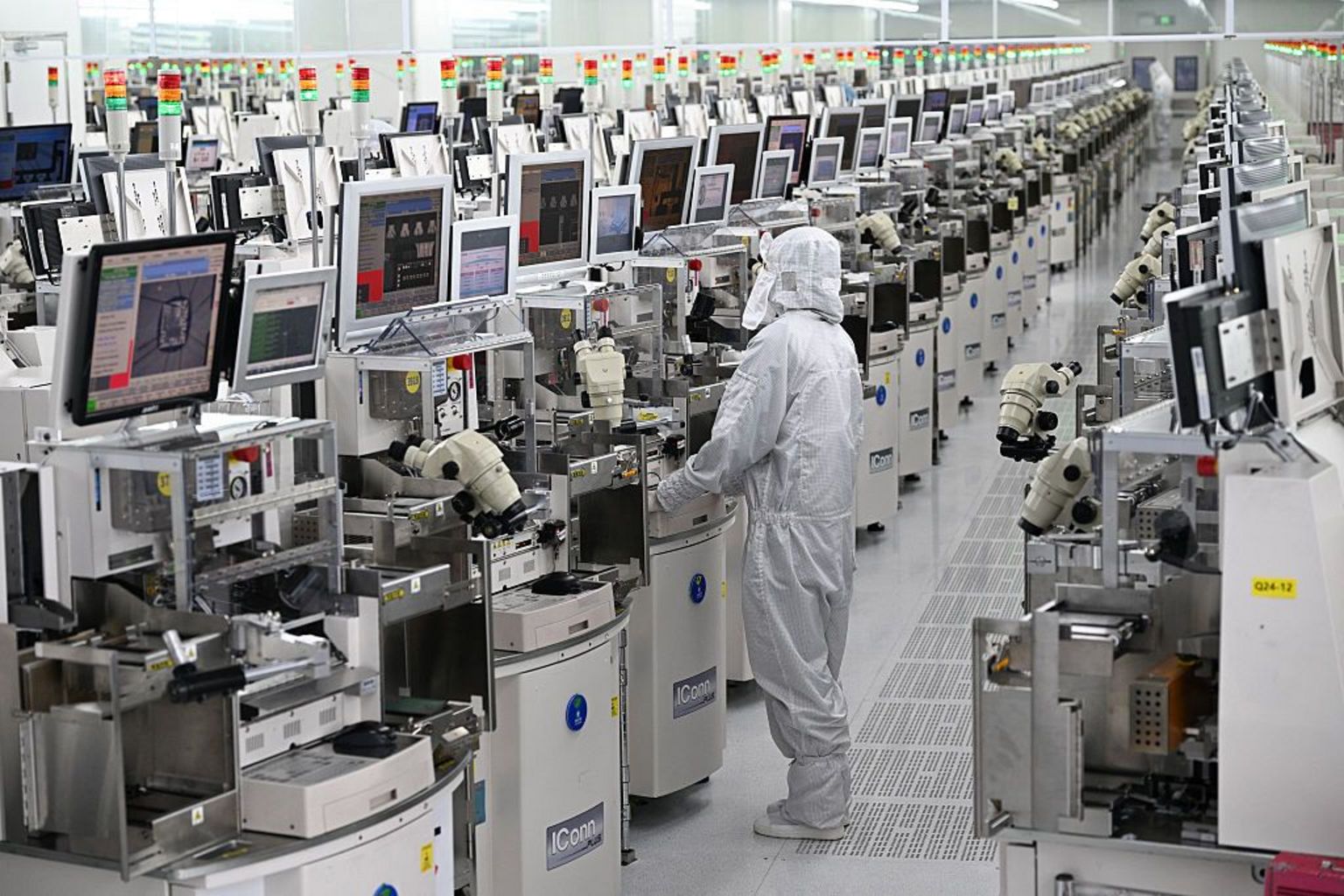 一名技术人员在中国东部江苏省宿迁市的一家半导体制造工厂内操作芯片加工设备